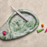Marble-patterned smoking accessory with colorful incense cones on a beige surface