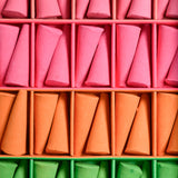 Colorful incense cones in pink, orange, and green arranged in a grid.